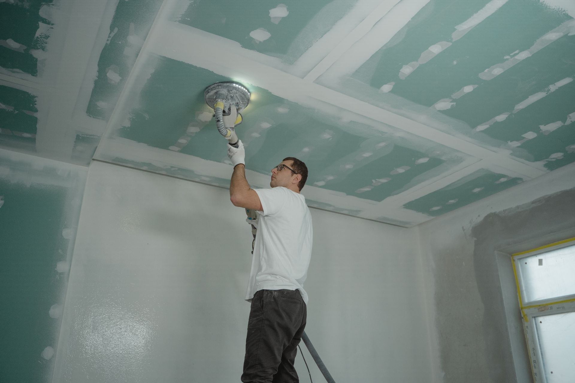 Worker polishing a ceiling during building maintenance works